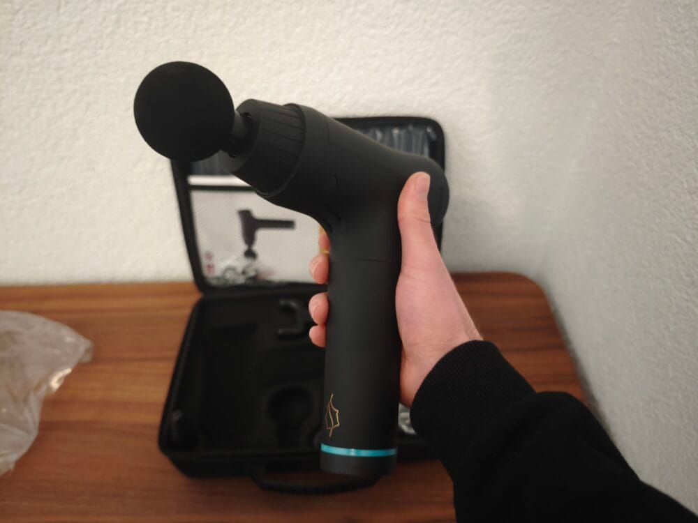 Jeg holder Comforth Muscleflow massagepistol i hånden klar til brug